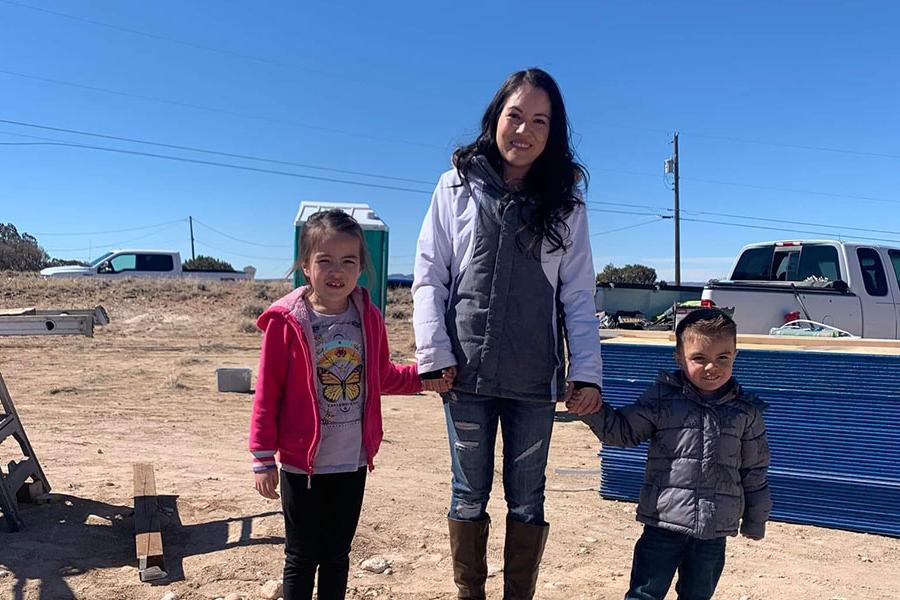 一名妇女和两个孩子站在“人类家园”新建房屋的现场.